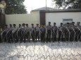 Police officers stand guard behind a razor wire barricade during a rally against persecution of Myanmar